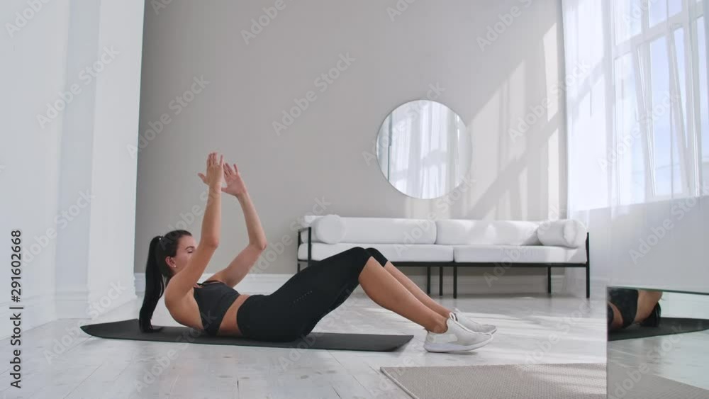 Home fitness concept. Woman doing abs crunches on floor at home, copy space. Home fitness concept. Woman doing abs crunches on floor at home, copy space.