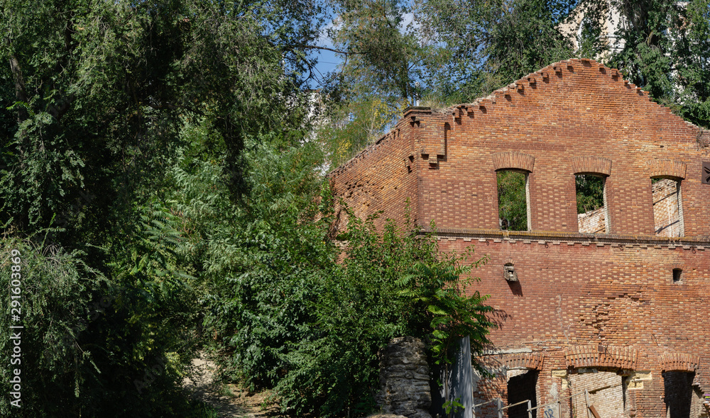 Fragments of ancient brick walls of abandoned Paramonovsky warehouses on  embankment of Rostov-on-Don. Warm sunny day.