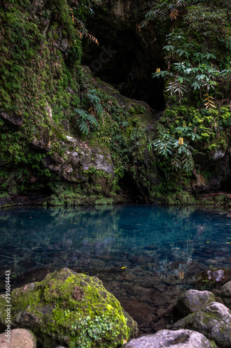 Poco Azul waterfall (blue well) in a subtropical forest with on the bottom an azure blue color pool surrounded by green plants, Achadinha, Nordeste, São Miguel Island, Azores, Portugal