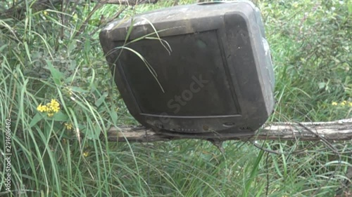 An old dirty telly falls off branch in woods. Decline television in traditional style concept. The laws of market and technological revolutions, new technologies. Super slow motion 1000 fps photo