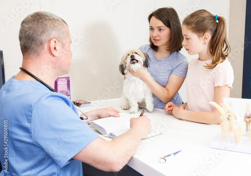 Troubled family with dog in veterinary office