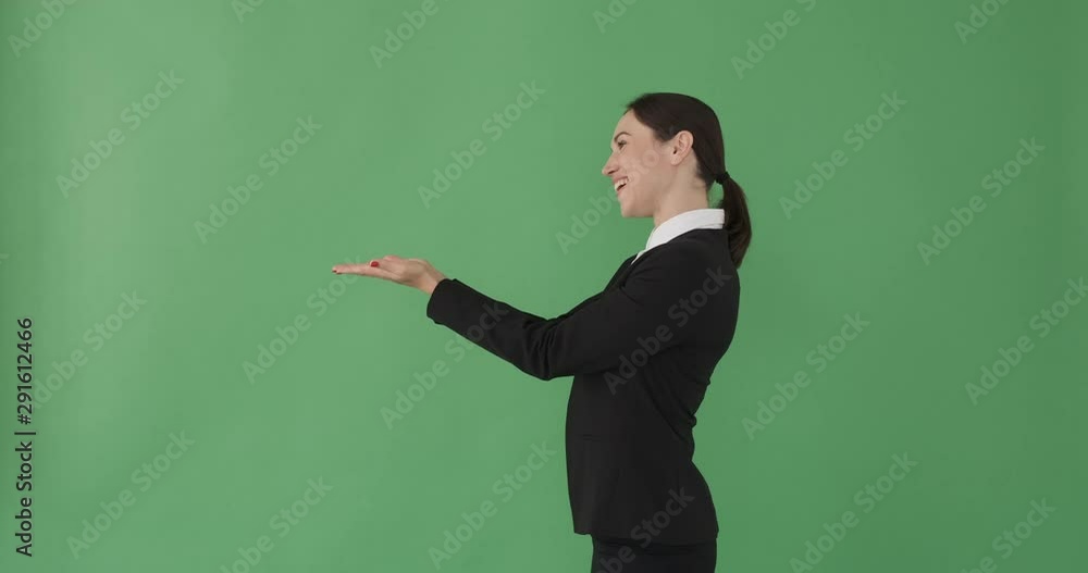 Businesswoman presenting copy space on her palm of hand over green background Businesswoman presenting copy space on her palm of hand over green background