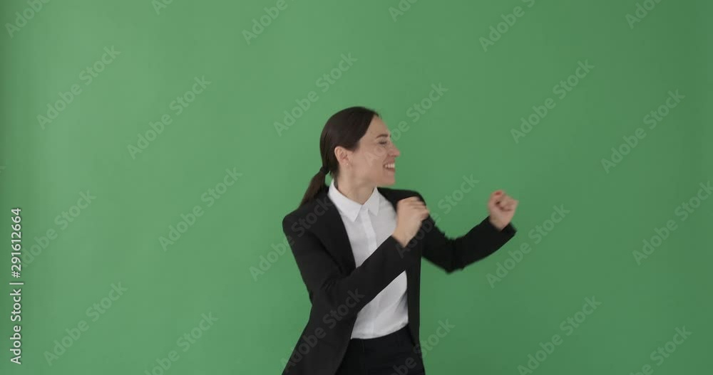 Excited businesswoman dancing over green background Excited businesswoman dancing over green background