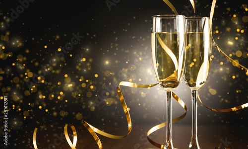Two glasses of champagne and a gold ribbon on a dark background in the sunlight