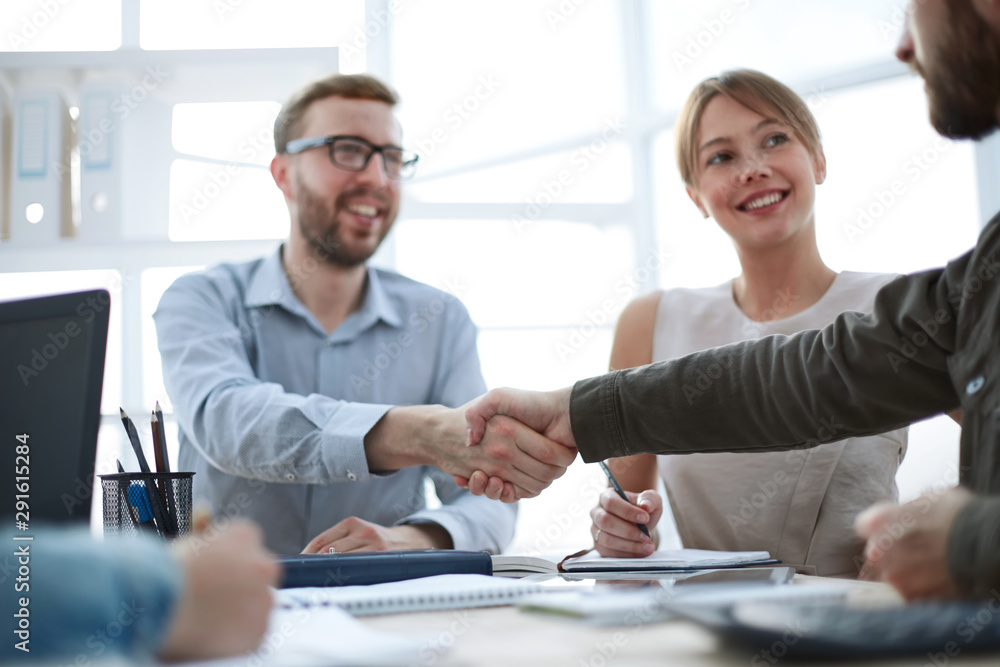 business partners shaking hands at a business meeting business partners shaking hands at a business meeting
