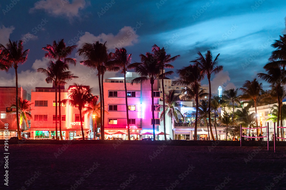 Naklejka Hotele i restauracje Miami Beach Ocean Drive o zachodzie słońca. Panoramę miasta z palmami w nocy. Życie nocne w stylu art deco na południowej plaży