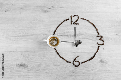Coffee beans folded in the form of a clock. Instead of the number 9, a cup of coffee, which means it's time to drink coffee