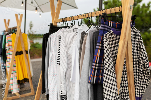 Racks with clothes outdoors. Designer sells clothes at a city fair © Kate