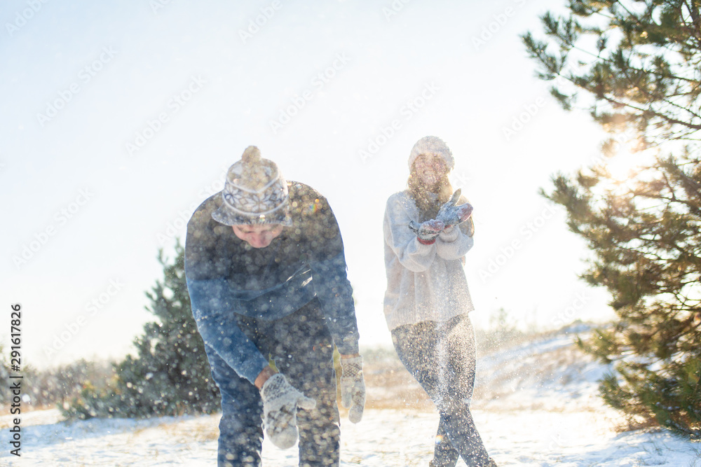 Loving couple play snowballs in winter in the forest. Throw each other snow. Laugh and have a good time Loving couple play snowballs in winter in the forest. Throw each other snow. Laugh and have a good time