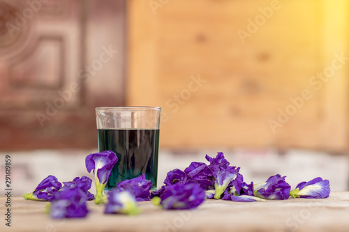 Butterfly pea flower cup with wooden wall blur.