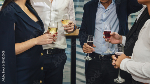 business people with glass of wine and champagne on hands having business discussion in corporate party to celebrate company success