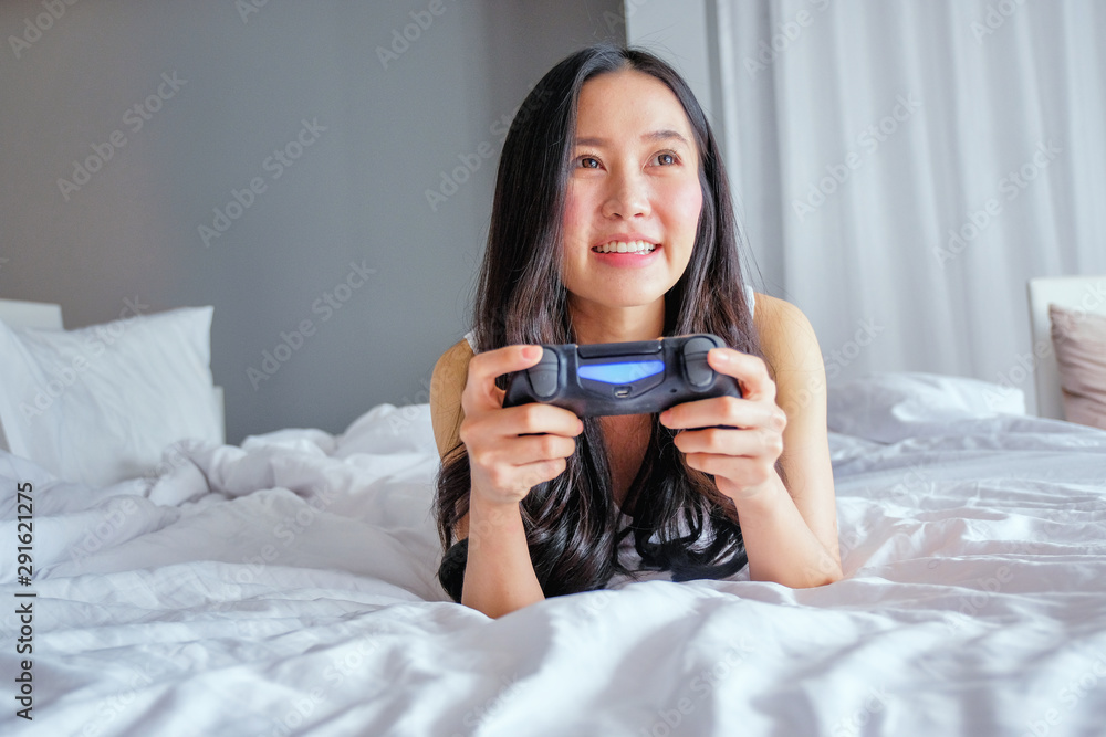 Beautiful girl playing video game on bed Beautiful girl playing video game on bed