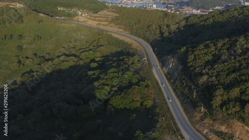 Cars moving on a mountain road and a city in background, on the sunset, Russia, Far East photo