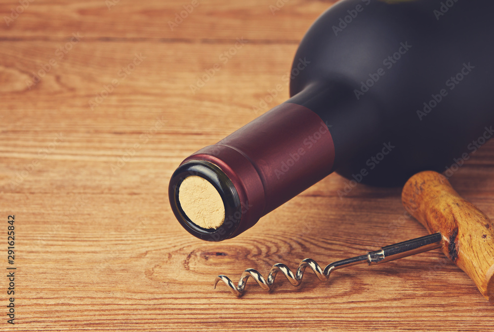 corkscrew and bottle of wine on the board