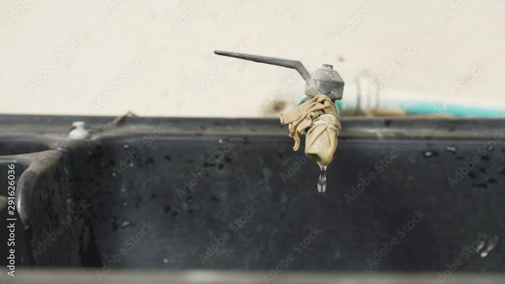 Leaking and dripping water from old faucet with covered cloth as filter Leaking and dripping water from old faucet with covered cloth as filter