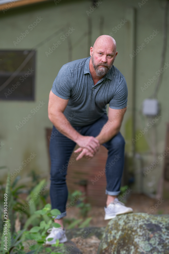 Image of a handsome American man with bald head and beard. Shot with tilt shift blur lower half of body Image of a handsome American man with bald head and beard. Shot with tilt shift blur lower half of body