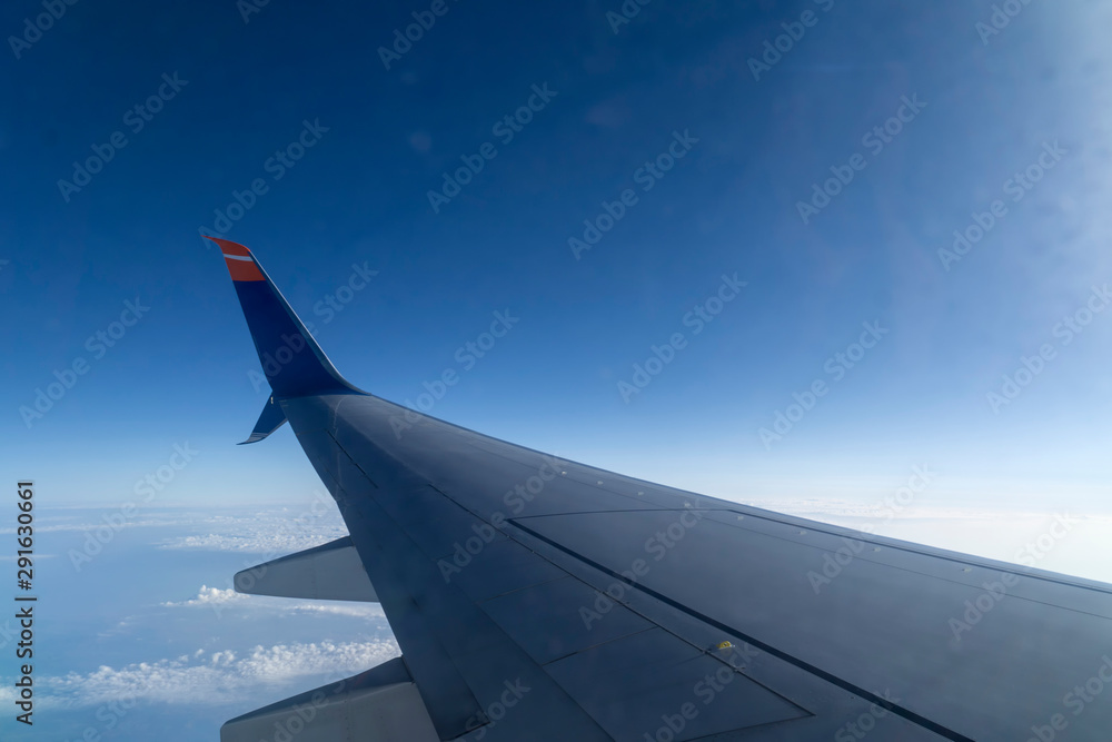 wing of airplane flying above clouds wing of airplane flying above clouds
