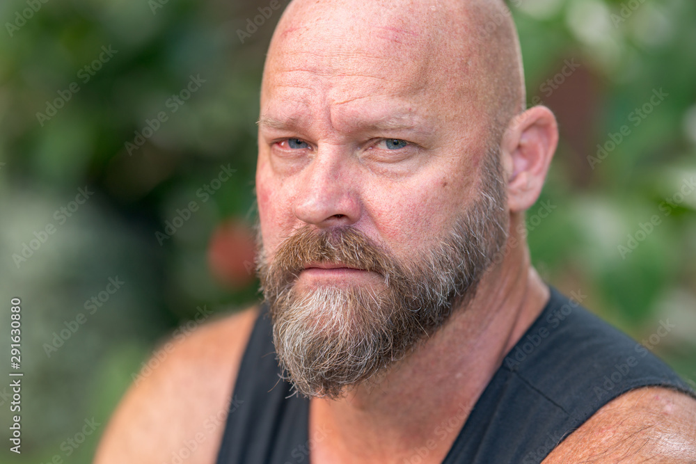 Photo of a handsome man looking towards camera. Guy is bald with beard Photo of a handsome man looking towards camera. Guy is bald with beard