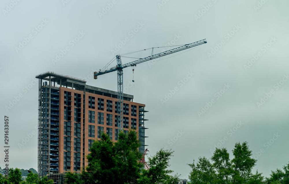 Fototapeta premium Blue crane infront of tall building under construction