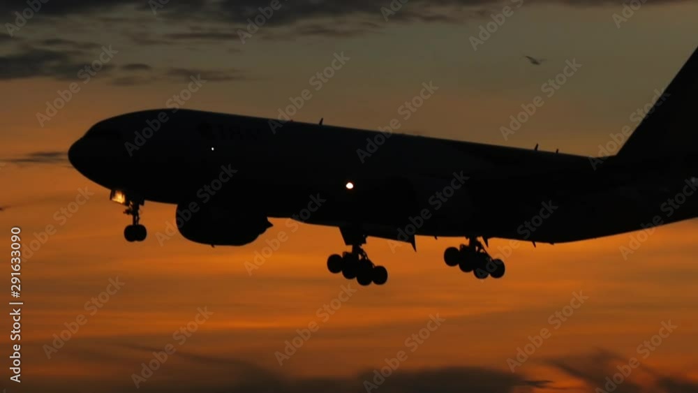 Silhouette of an airplane in the night sky against a background of thunderclouds Silhouette of an airplane in the night sky against a background of thunderclouds