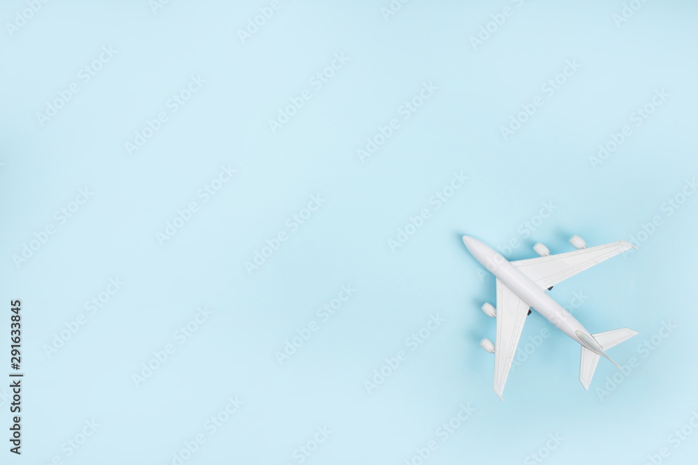 Fototapeta The white plane model on a blue background. Travel Concept.
