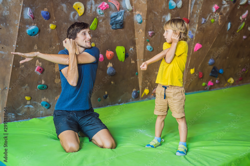 Fototapeta premium Dad and son at the climbing wall. Family sport, healthy lifestyle, happy family