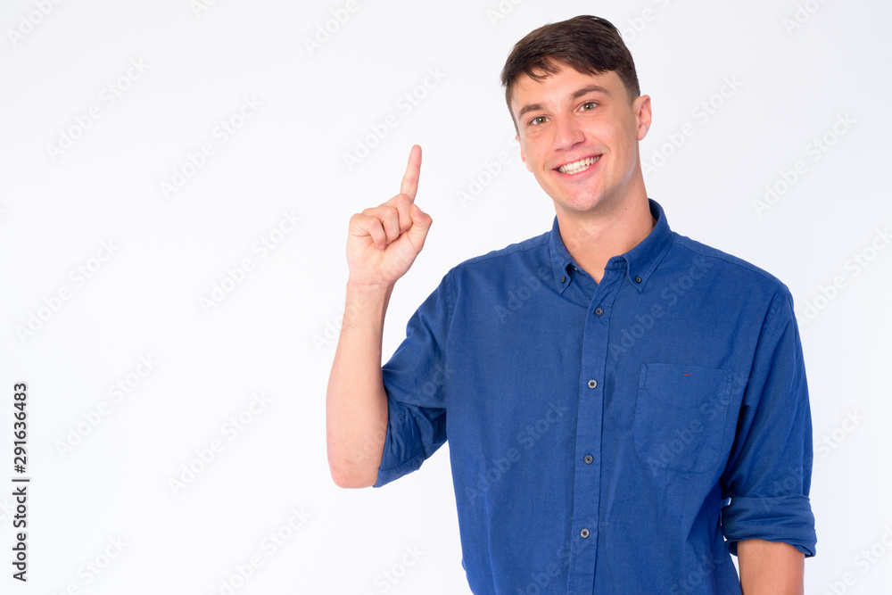 Portrait of happy young handsome businessman pointing up Portrait of happy young handsome businessman pointing up