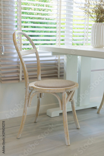 Vintage wood chair by the window with white curtain. 