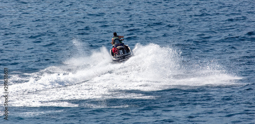 A motorcycle is racing in the blue water of the sea