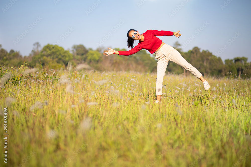 Hipster Asian woman in red and sunglasses on white flower and grass field Hipster Asian woman in red and sunglasses on white flower and grass field