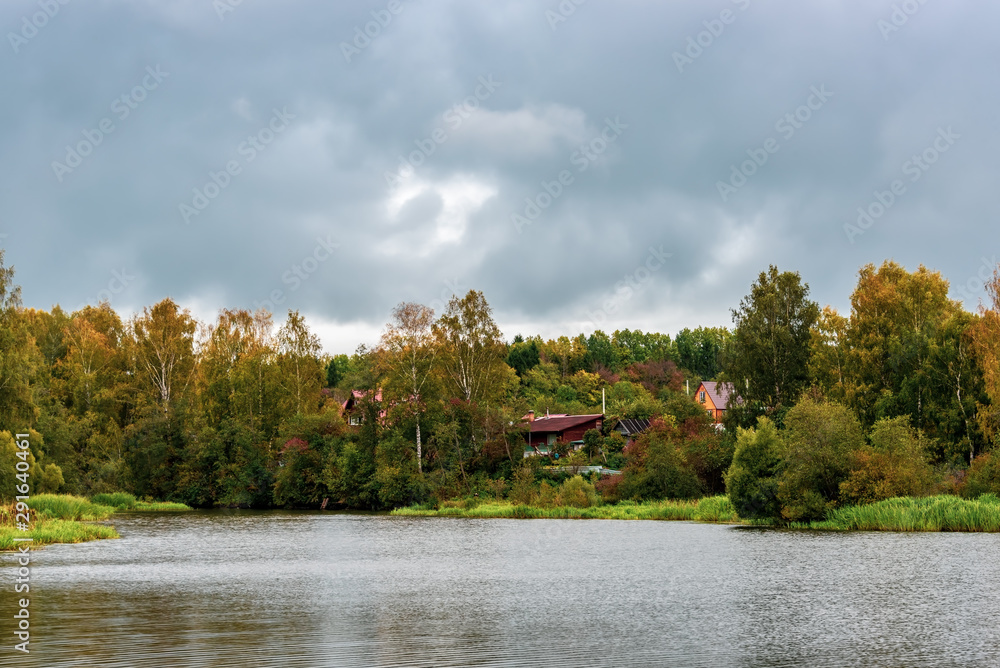 Village by the lake in cloudy weather. Rural landscape Village by the lake in cloudy weather. Rural landscape