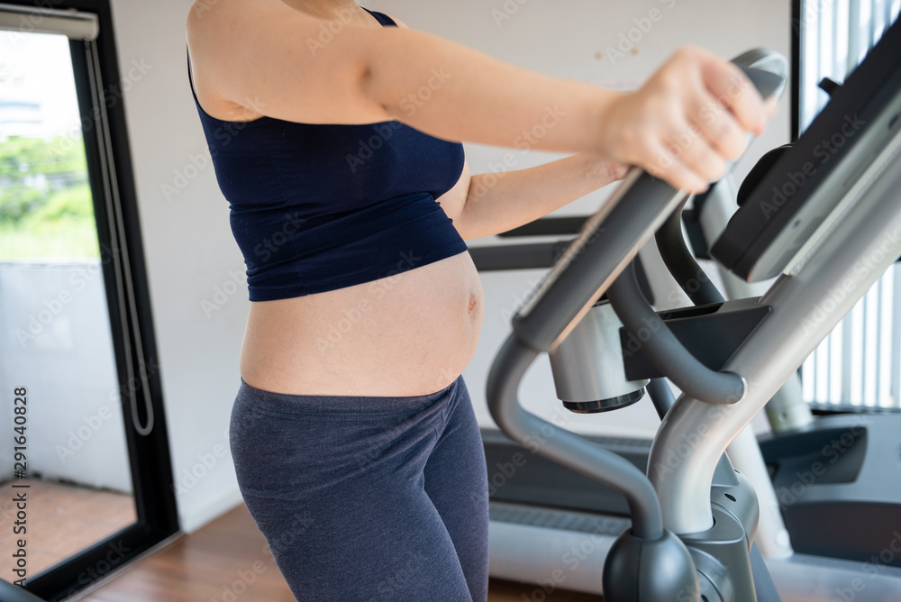 Cropped image of pregnant woman in fitness clothes exercising Cropped image of pregnant woman in fitness clothes exercising