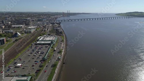 High level drone footage flying towards Tay Road Bridge, Dundee, Scotland with V&A museum and Riverside Drive on left and River Tay on right on beautiful blue sky sunny day. photo