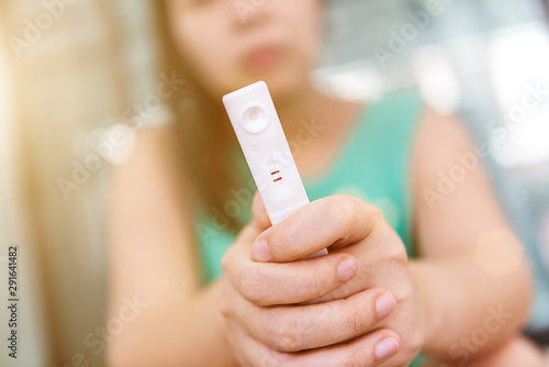 Young woman holding a pregnancy test