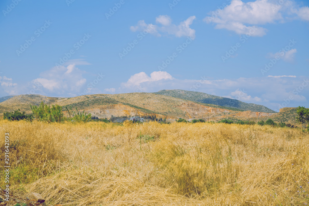 Greek Republic. Fields and mountains, grass and trees. In the distance mountains and sky. 13. Sep. 2019. Travel photo.