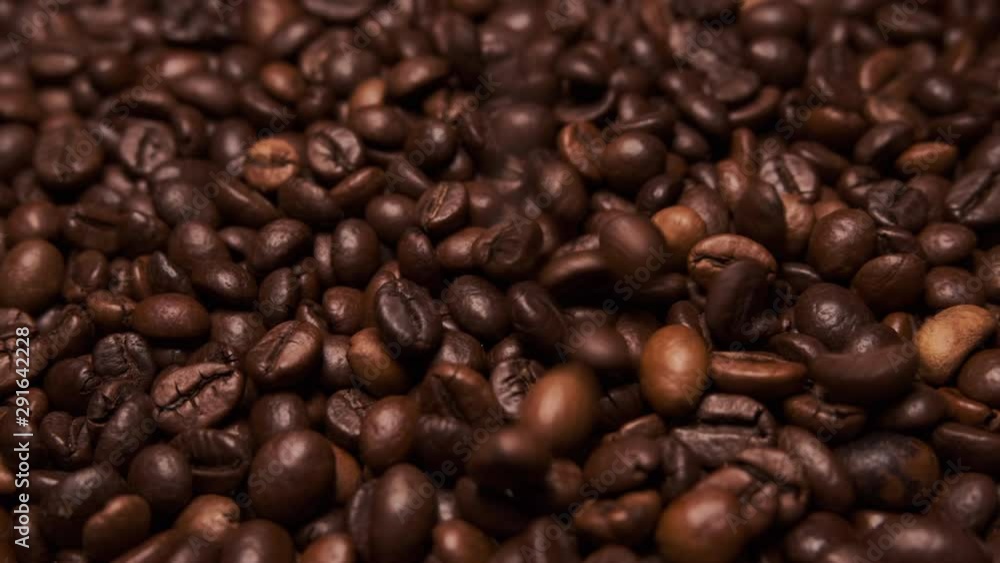 Fresh roasted coffee beans close up, falling from above. Slow zoom in Fresh roasted coffee beans close up, falling from above. Slow zoom in