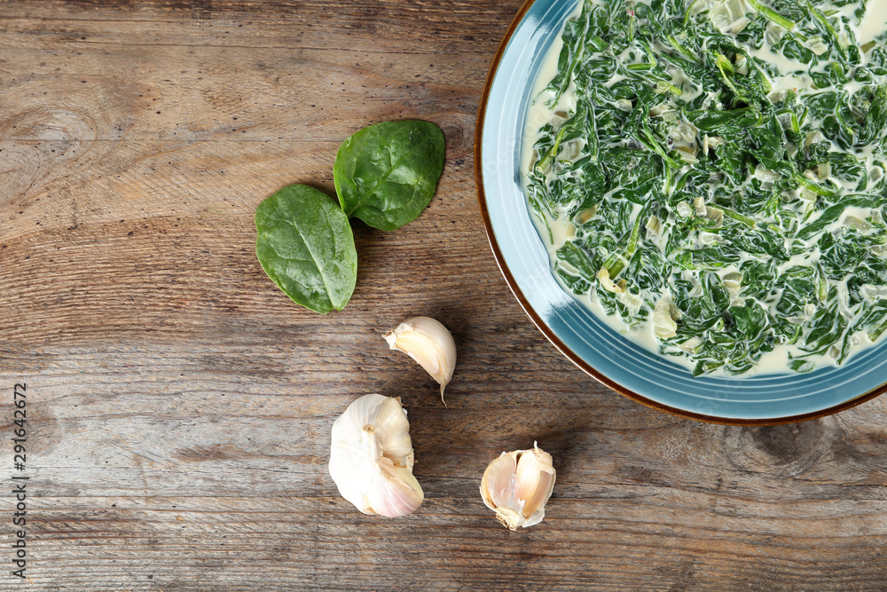 Tasty spinach dip on wooden table, flat lay Tasty spinach dip on wooden table, flat lay