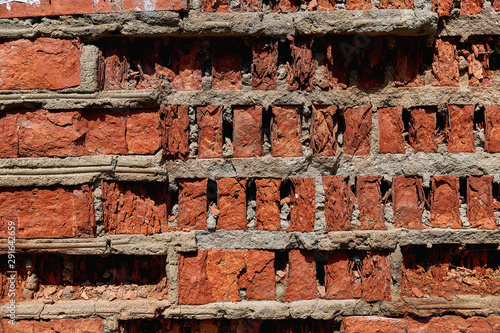 Old brick wall with falling apart bricks. Brick background close-up.