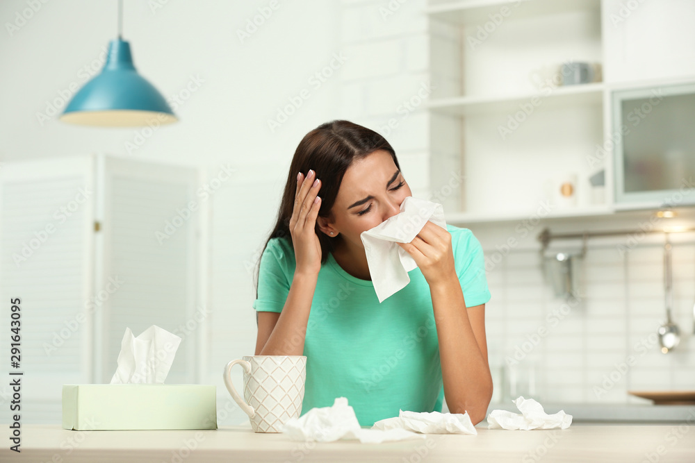 Young woman suffering from allergy in kitchen Young woman suffering from allergy in kitchen