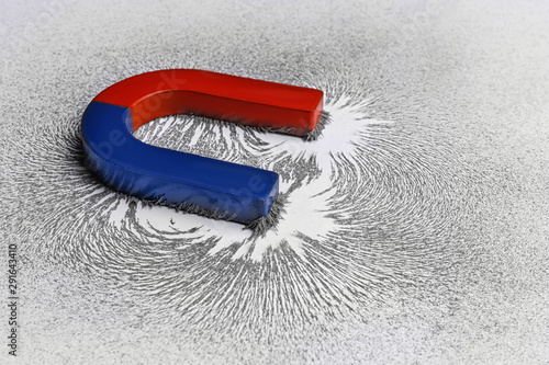 Fotografija Red and blue horseshoe magnet with iron filings on white background