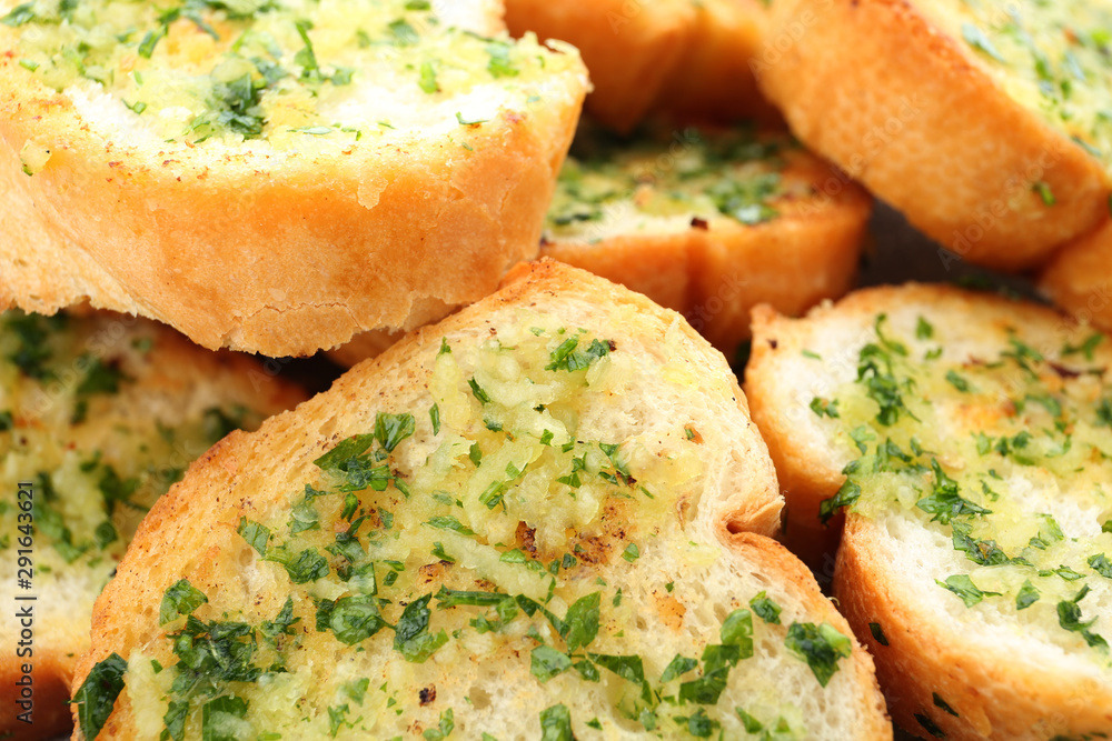 Slices of toasted bread with garlic and herbs as background, closeup Slices of toasted bread with garlic and herbs as background, closeup