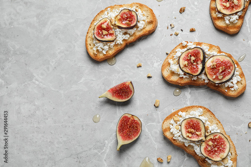 Bruschettas with cheese and figs on marble table, flat lay. Space for text