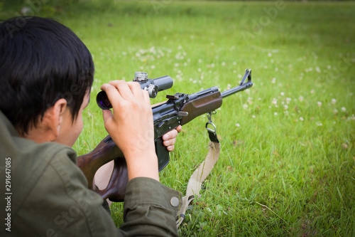 The hunter with a gun takes aim. The concept of hunting, hobby, active life. The hunter has a rifle with a telescopic sight. Close-up image.