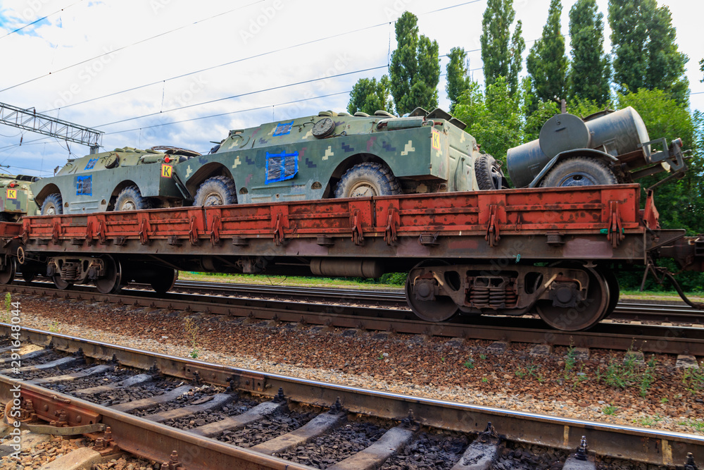 Cargo train carrying military vehicles on railway flat wagons Cargo train carrying military vehicles on railway flat wagons