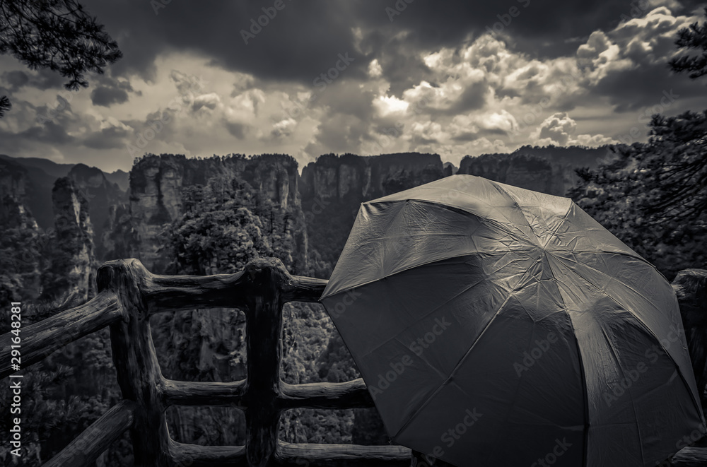 Tourists holding umbrella on the mountain viewpoint
