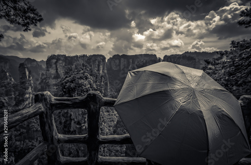 Obraz na płótnie Tourists holding umbrella on the mountain viewpoint w salonie