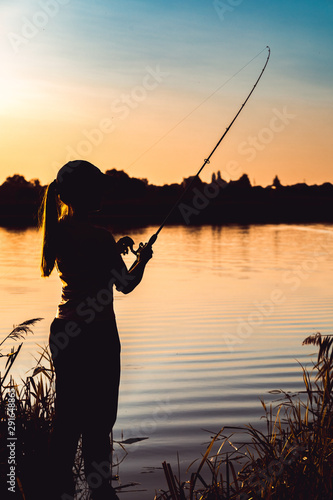 Wallpaper Mural Silhouette of a woman at sunset with a fishing rod near the pond. Torontodigital.ca