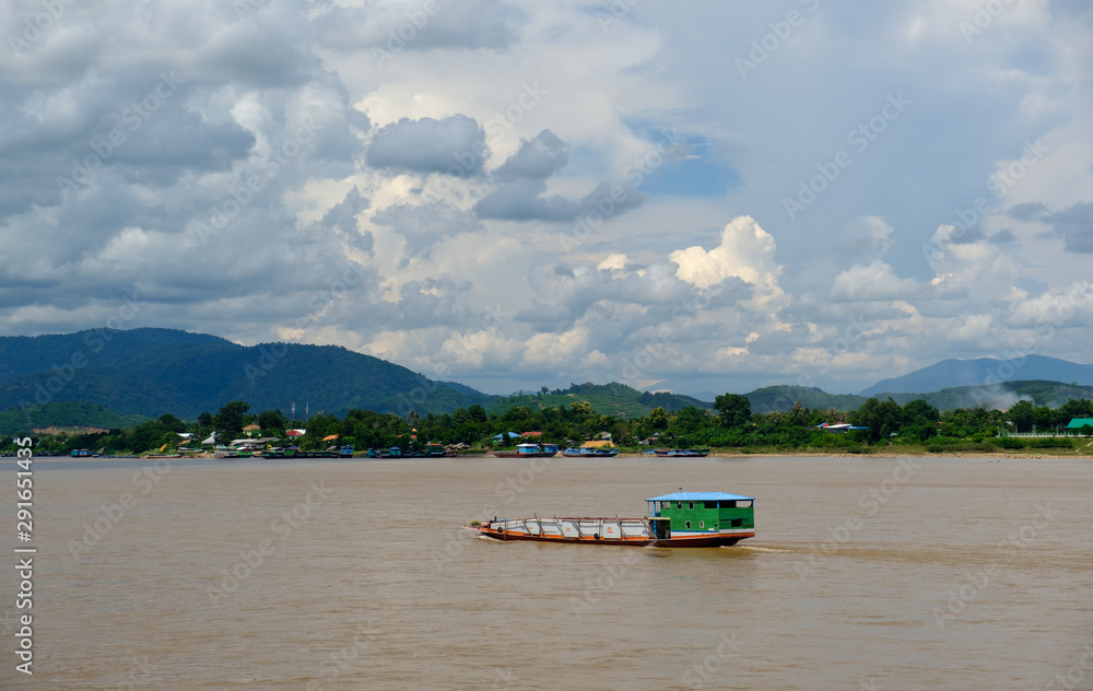 Fototapeta premium White clouds with a blue sky,Long tail boat moored at the MEKHONG River