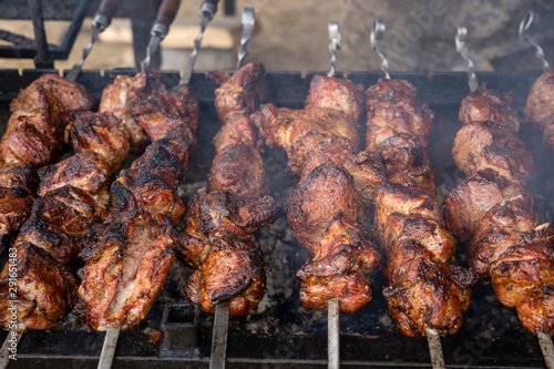 Grilled kebab cooking on metal skewer closeup. Roasted meat cooked at barbecue. BBQ fresh beef meat chop slices. Traditional eastern dish  shish kebab