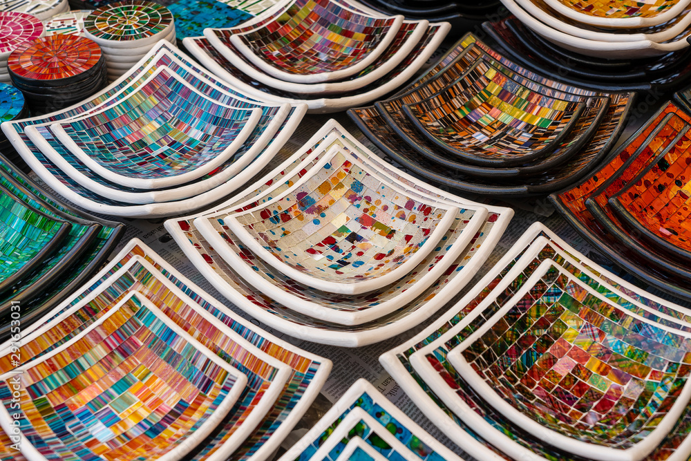 Colorful mosaic decorative plates on the market for sale on local street market in Ubud, island Bali, Indonesia . Souvenirs for tourist
